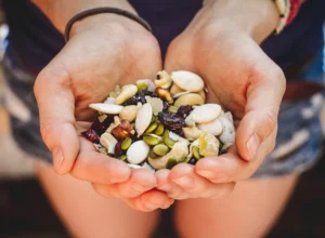 hands cupping trail mix - Manvik Foods Dry Fruits for Weight Loss